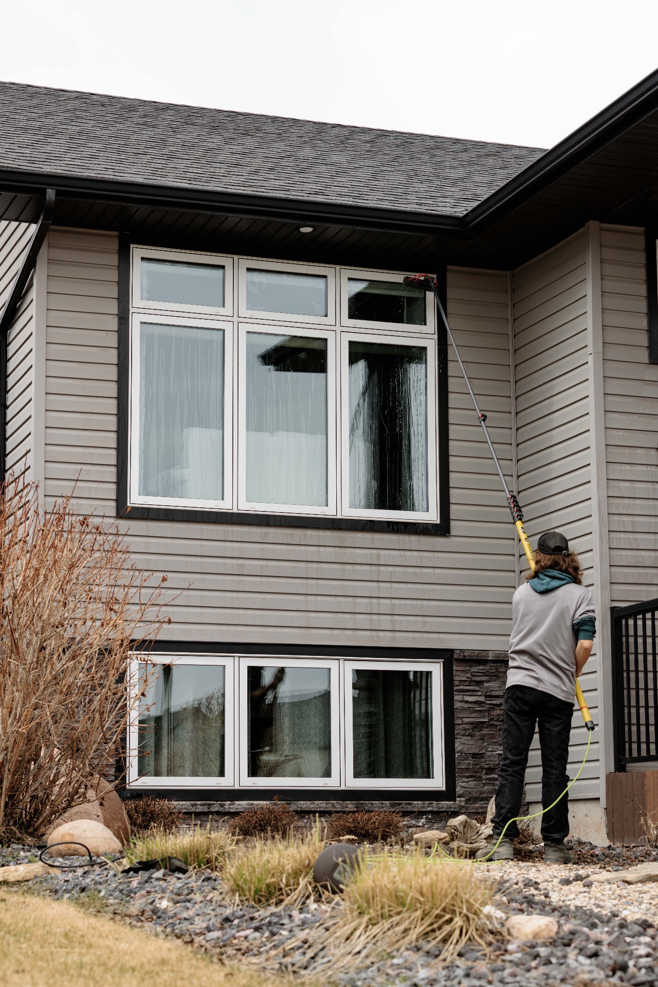 Technician cleaning tall residential windows
