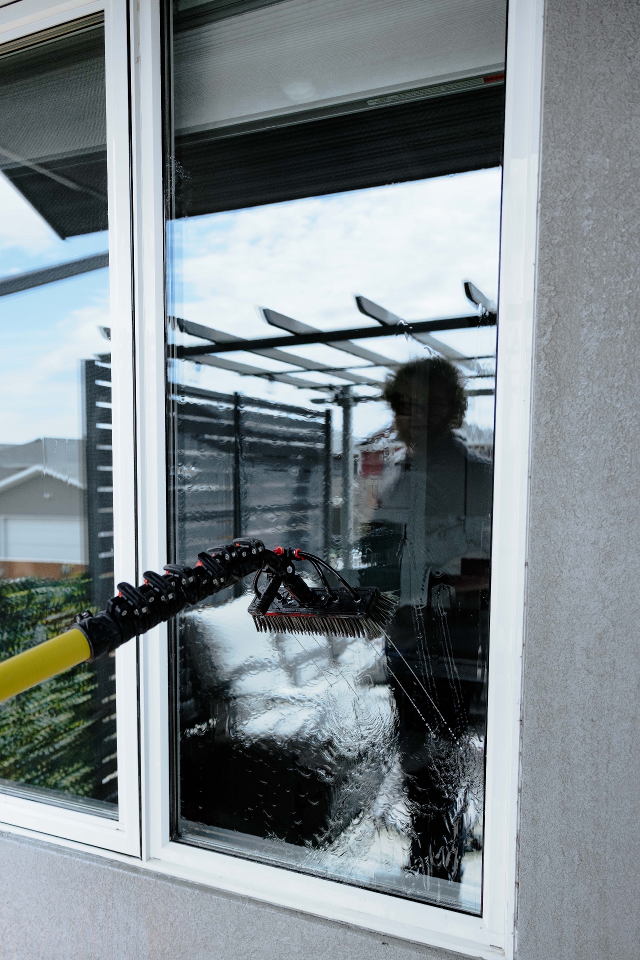 Exterior window being rinsed during a cleaning visit